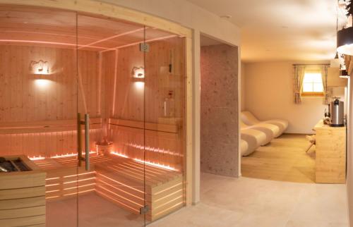マドンナ・ディ・カンピリオにあるHotel Garnì Sant'Antonio con Spaのガラス張りのシャワーが備わる客室です。
