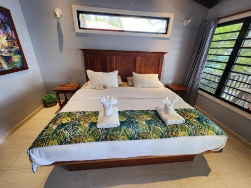 a bedroom with a bed with shoes on it at Maya Beach Hotel in Maya Beach