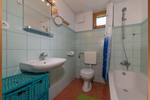 uma casa de banho com um lavatório, um WC e uma banheira em The Red House em Spodnje Gorje