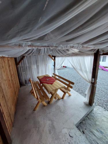 a tent with a table and chairs under it at Casuta De Sub Munte Cârțișoara in Cîrţişoara