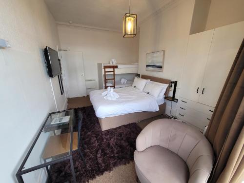 a small room with a bed and a chair at Sea View flat 2 with Fast WiFi and FREE parking in Scarborough