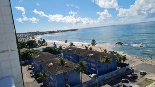 widok na plażę z niebieskimi budynkami i ocean w obiekcie Smart Itapuä w mieście Salvador