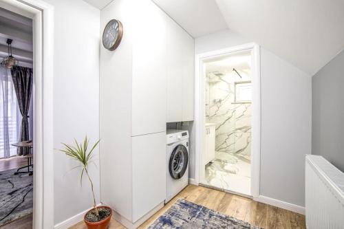 a white laundry room with a washer and dryer at Nannie Apartaments Skenges in Rădăuţi