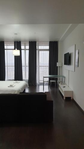 a hotel room with a bed and a glass table at Metropolia Apartments in Rīga