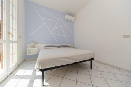 a bedroom with a bed with a blue wall at Villetta Belgrado in Cesenatico