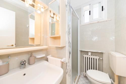 a white bathroom with a toilet and a sink at Villetta Belgrado in Cesenatico