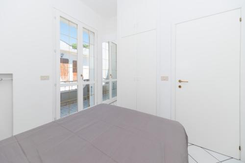 a white room with a bed and a window at Villetta Belgrado in Cesenatico