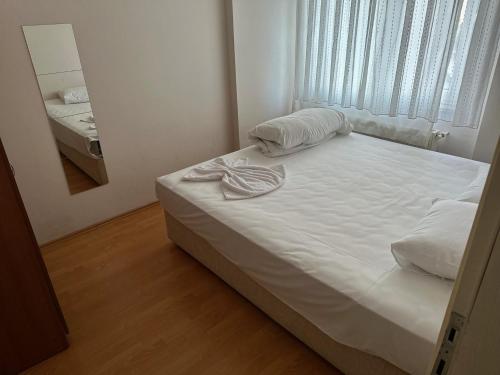 - un lit blanc dans une chambre avec un miroir dans l'établissement Kamelya, à Nilüfer