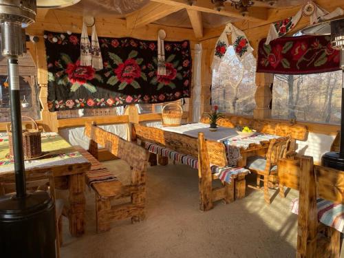 un comedor con mesas de madera y sillas en una cabaña en Cabanele Rus en Budeşti