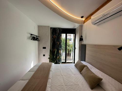 a bedroom with a large bed and a large window at La Mini Casa in Córdoba