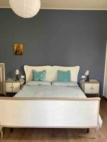 a bedroom with a large white bed with blue pillows at Casa Nina, intero appartamento in Fornaci di Barga