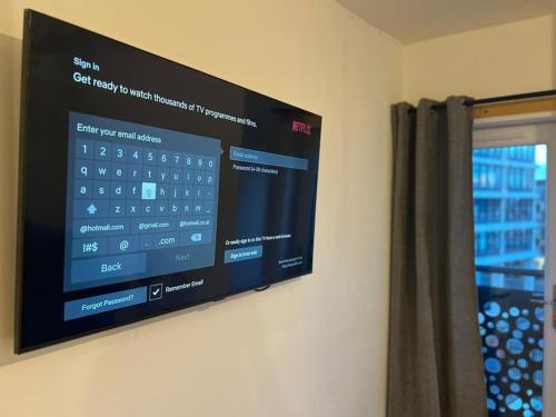 a flat screen tv on a wall next to a window at HU1 Hull City Centre Modern Apartment WIFI BATH H9 in Hull