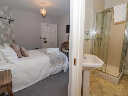 ein Schlafzimmer mit einem Bett, einem Waschbecken und einer Dusche in der Unterkunft Manor House in York