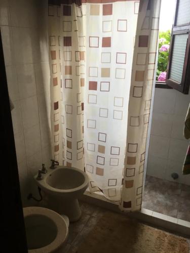 a bathroom with a toilet and a shower curtain at La Rosada in La Paloma