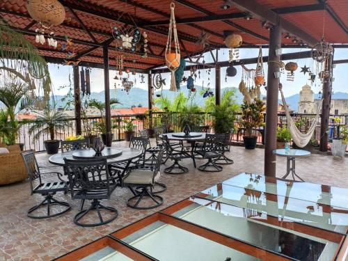 an outdoor patio with tables and chairs and chandeliers at Grann Posada Xilitla in Xilitla