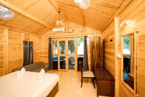 a room with two beds and a chair in it at orange sky beach bungalow in Agonda