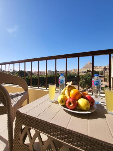 a plate of fruit on a table on a balcony at Lucky Pyramids View in Cairo
