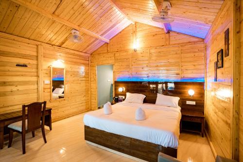 a bedroom with a bed in a wooden room at orange sky beach bungalow in Agonda