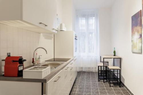 cocina blanca con fregadero y encimera en DR Apartments Boxhagener Kiez en Berlín
