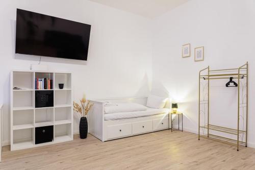 sala de estar con cama blanca y TV de pantalla plana en DR Apartments Boxhagener Kiez en Berlín
