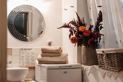 a bathroom with a toilet and a mirror and towels at Willa Tyrolczyk in Karpacz