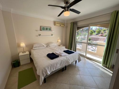 a bedroom with a bed with a ceiling fan and a window at Amazing Beachfront townhouse chalet Ain Sokhna LaVista 1 in Ain Sokhna