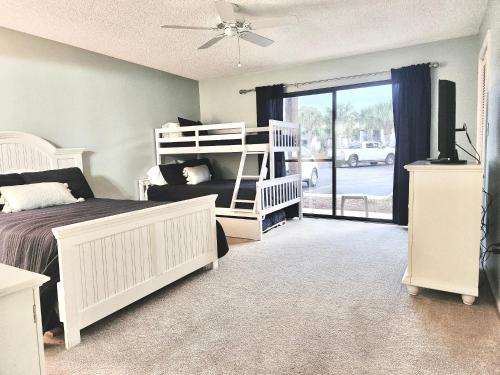 a bedroom with a bed and a bunk bed at Edgewater RESORT BEACH & GOLF Villa! Steps to the Beach! in Panama City Beach