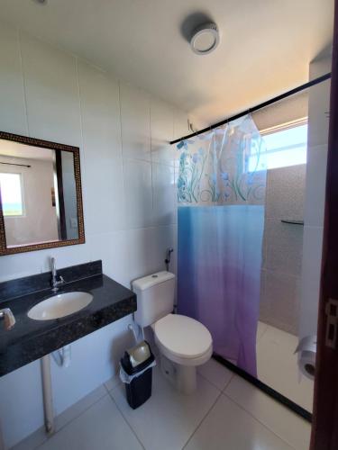 Un baño con inodoro, lavabo y ducha. en Residencial Rio Gurugi, en Conde