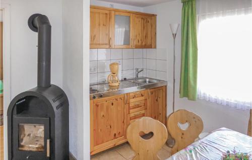 a kitchen with a wood stove in the corner at Nice Home In Eichigt-ot Sssebach With Kitchen in Eichigt
