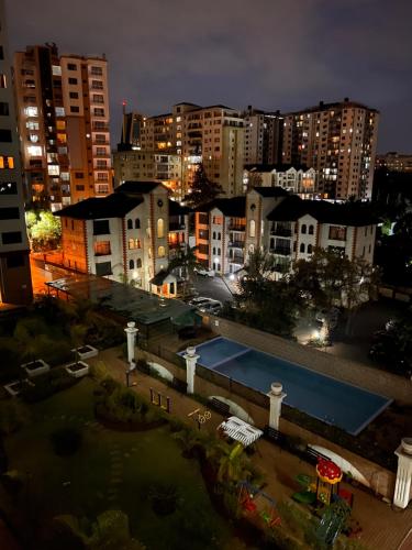 une ville de nuit avec une piscine et des bâtiments dans l'établissement Crestpark 3br furnished apt, à Nairobi