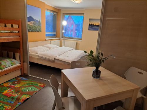 a room with two beds and a table and a dining room at Resident Harrachov Family apartment in Harrachov