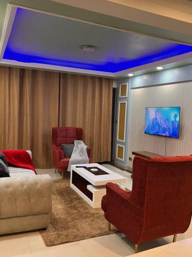 - un salon avec un canapé, des chaises et une télévision dans l'établissement Crestpark 3br furnished apt, à Nairobi