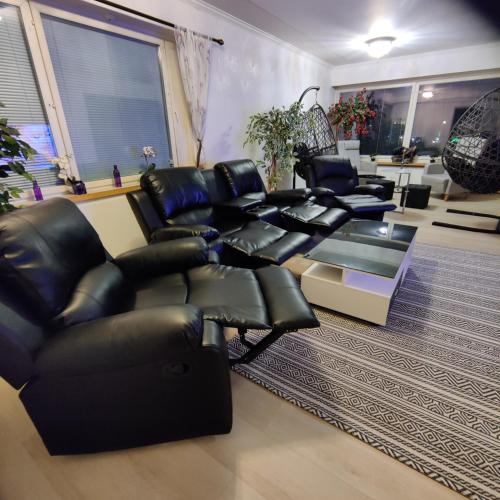 a living room with black leather chairs and a table at Sun in Närpiö