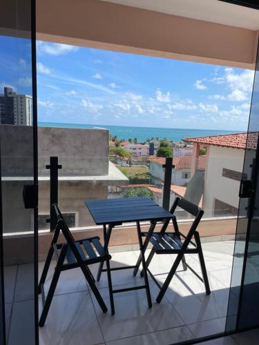 a table and chairs on a balcony with a view of the ocean at Sol de Pirangi in Parnamirim