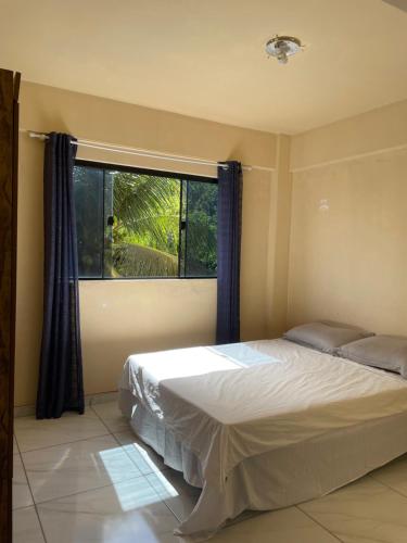 a bedroom with a bed and a large window at Sol de Pirangi in Parnamirim