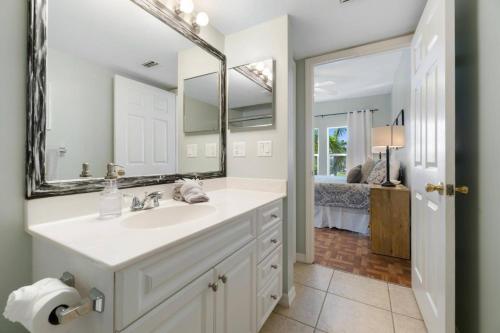 a bathroom with a sink and a mirror and a bedroom at Collier Condo #202 in Marco Island