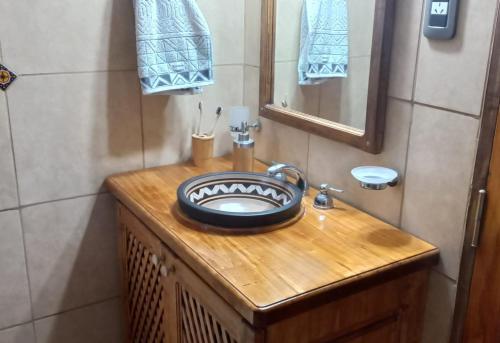 a bathroom with a sink and a mirror on a wooden counter at Posada Almazen in Las Compuertas