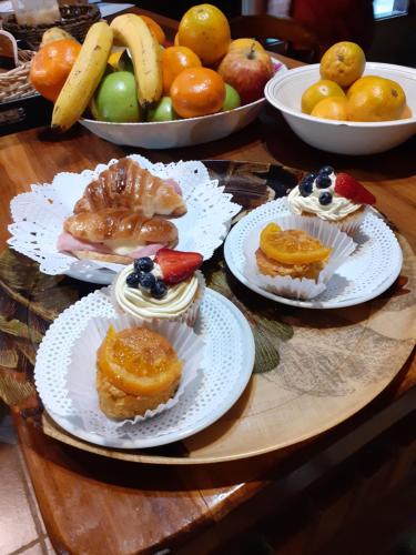 una mesa cubierta con platos de bollería y fruta en Posada Almazen, en Las Compuertas