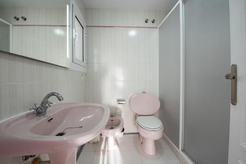 La salle de bains blanche est pourvue d'un lavabo et de toilettes. dans l'établissement Holiday Beach Varadero, à Santa Pola