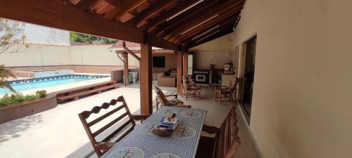 a table and chairs on a patio with a pool at Casa Ampla e confortável in São Sebastião