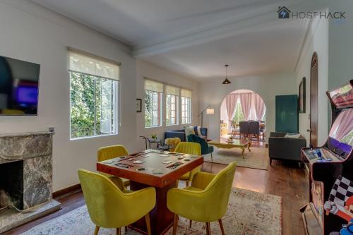 a living room with a table and yellow chairs at Refurbished Mansion with Garden & Patio in Las Lomas - Monte Blanco in Mexico City
