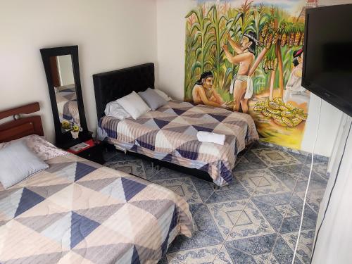 Habitación con 2 camas y una pintura en la pared. en La Cachaca, en Bogotá