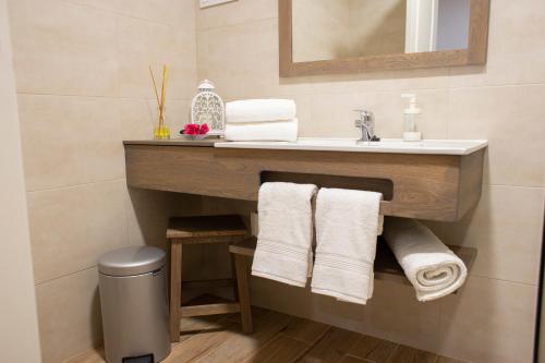 a bathroom with a vanity with a sink and towels at Azafrán Consuegra in Consuegra