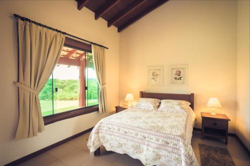 a bedroom with a bed and a window at Pousada Boyrá in Bonito