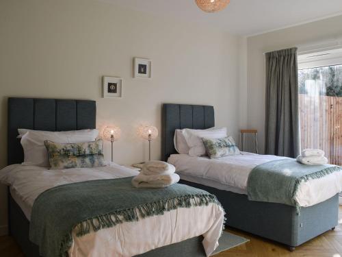 two beds sitting next to each other in a bedroom at Briar Cottage in Gargunnock