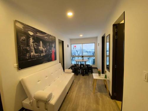 a living room with a white couch and a table at Torres de San Vicente 2 hab in Manizales
