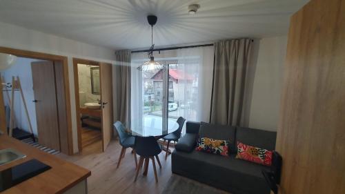 a living room with a couch and a table at Apartamenty Nowa Osada - by VillaOlimpijska2 in Wisła