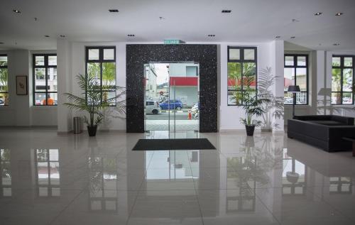 a lobby with a black couch and potted plants at Cathayana Hotel Kuantan in Kuantan