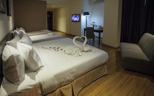 a hotel room with two swans on a bed at Cathayana Hotel Kuantan in Kuantan