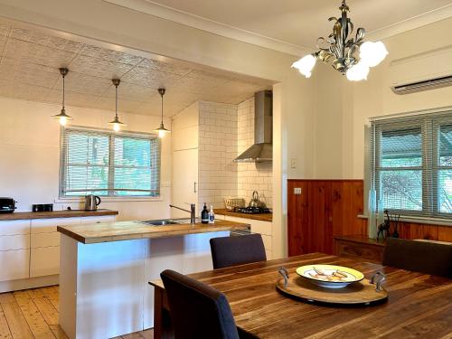 Una cocina con una mesa de madera y un comedor. en Cherry Blossom Cottage - Beechworth-Getaways, en Beechworth